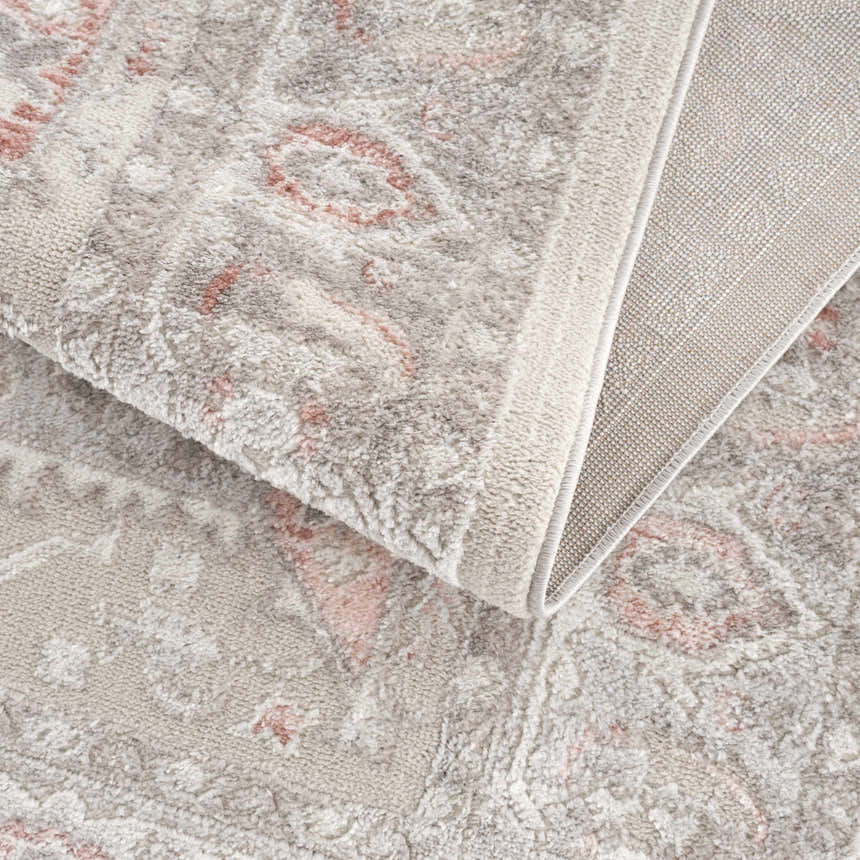 Close up of the Damla Area Rug in gray and pink, showing the traditional pattern and soft texture. Fold