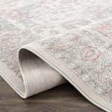 Close-up of the Damla Area Rug showing its gray and pink traditional pattern and machine woven construction. Fold