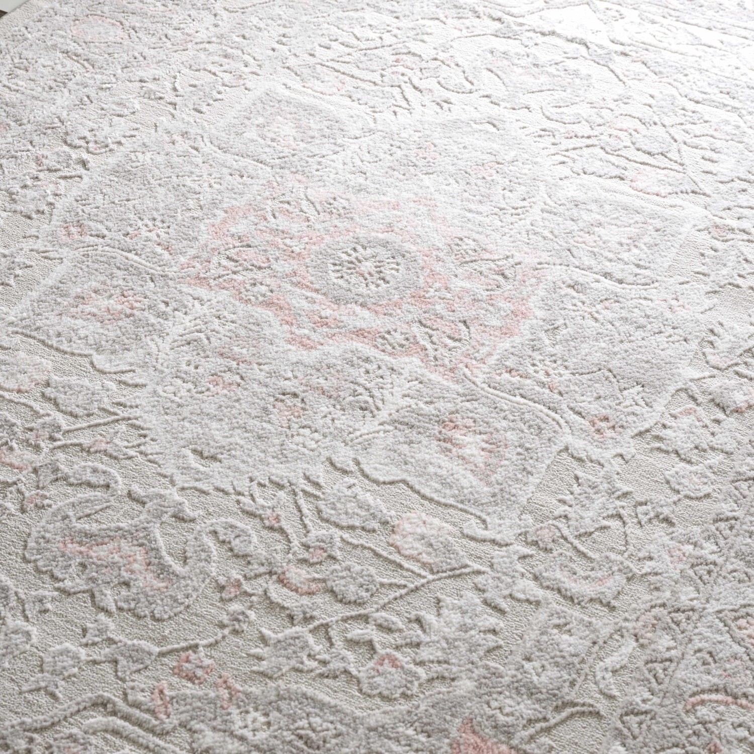 Close-up of the Damla Area Rug with a traditional gray and pink floral pattern and soft, textured pile. Texture