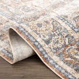 Close-up of the Arias Blue Boutique Washable Rug showing its faded driftwood, nutmeg, and gray traditional pattern. Fold