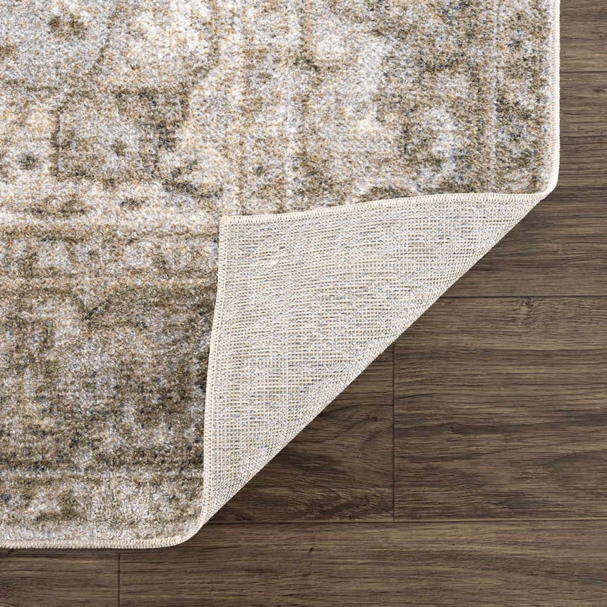 Close-up of the Gael Boutique Washable Rug showing the vintage tan, olive, and light blue pattern and rug backing. Fold
