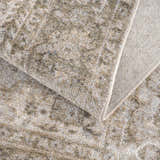 Close-up of the Gael Boutique Washable Rug showing its traditional tan, olive, and light blue vintage-style pattern and woven texture. Fold