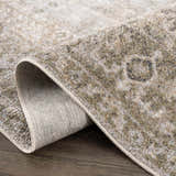 Close-up of the Gael Boutique Washable Rug showing the traditional light blue, olive, tan, and yellow vintage pattern. Fold