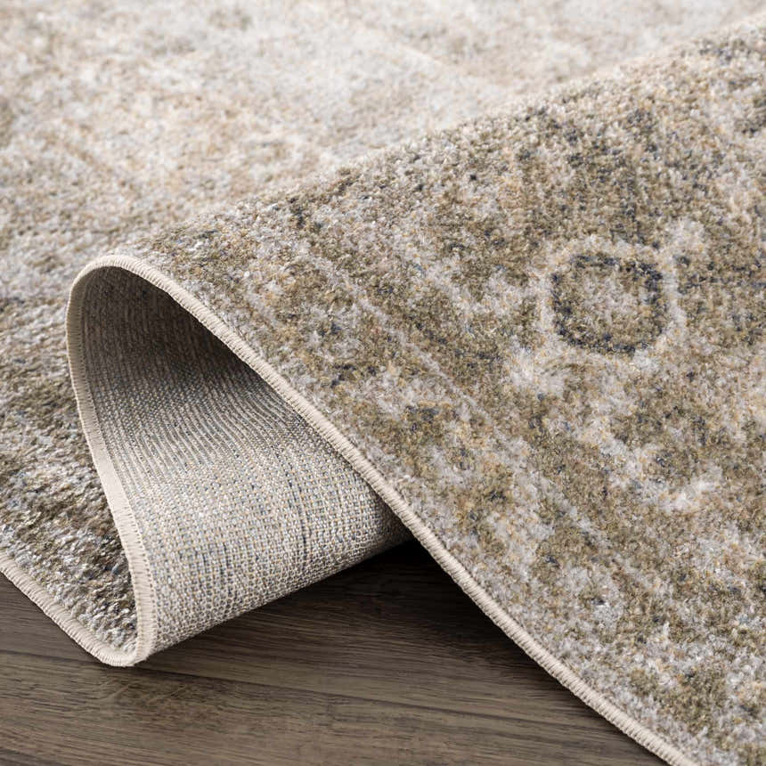 Close-up of the Gael Boutique Washable Rug showing the traditional light blue, olive, tan, and yellow vintage pattern. Fold