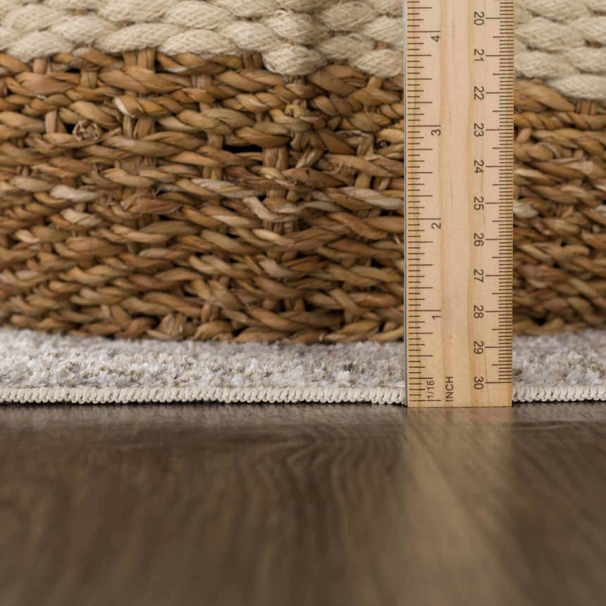 Close-up of the Gael Boutique Washable Rug showing the rug's edge, pile height, and woven texture against a wood floor. Pile