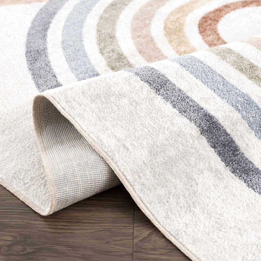 Close-up of the Giza Washable Area Rug featuring a rainbow pattern in gray, blue, tan, and white on a textured polyester weave. Fold