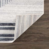 Close up of the Thad Medium Gray Washable Area Rug showing geometric design, soft texture, and durable backing. Fold