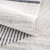 Close-up of the Thad Medium Gray Washable Area Rug showing its geometric stripe pattern and soft, textured pile. Fold
