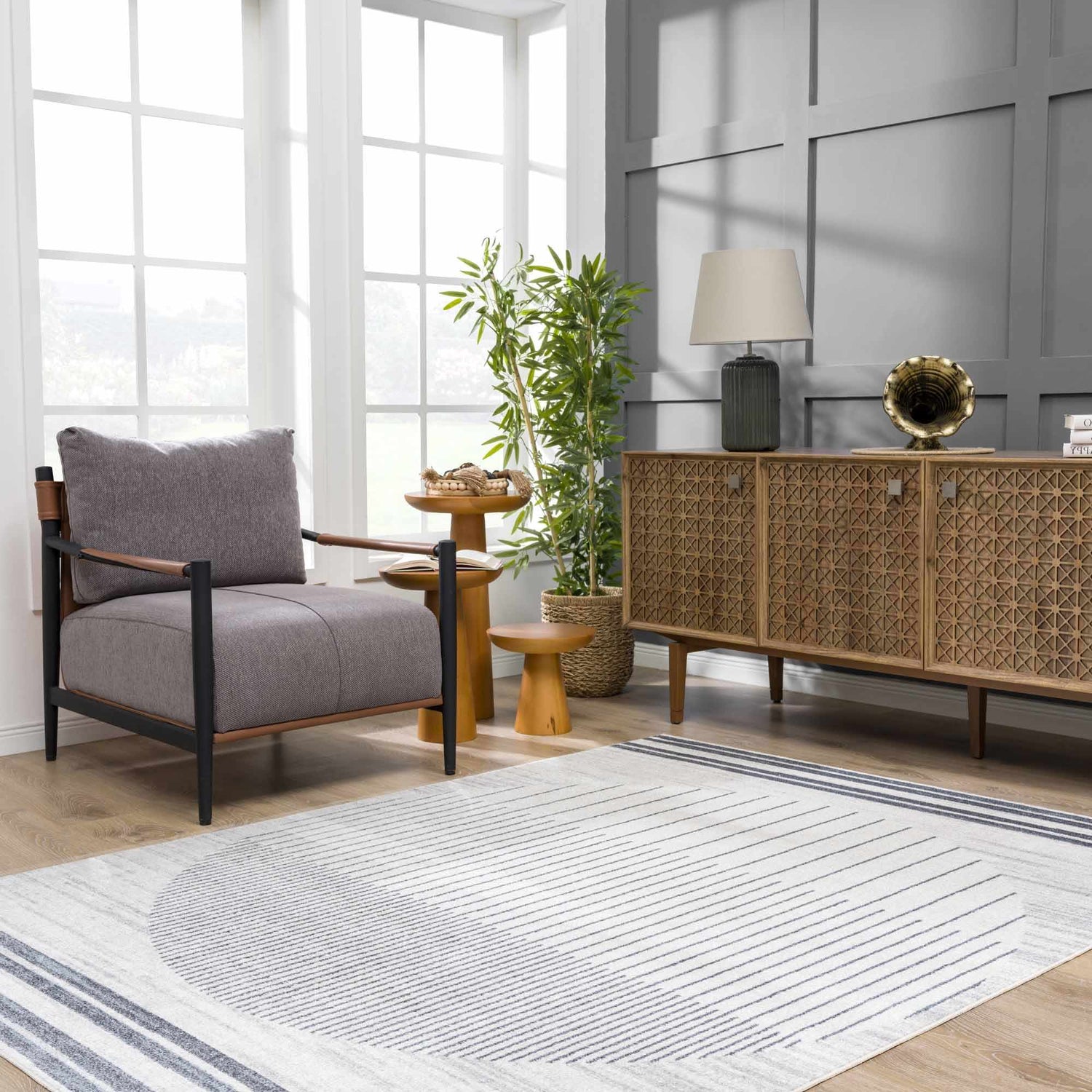 Living room scene with a gray chair and the Thad Medium Gray Washable Area Rug featuring a geometric design. Roomscene-Rectangle