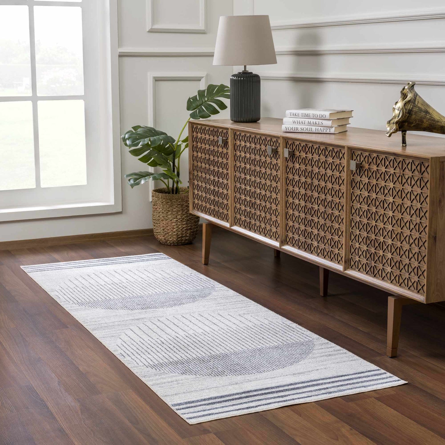 Entryway with geometric Thad Medium Gray Washable Area Rug, wood console table, lamp, and monstera plant. Roomscene-Runner