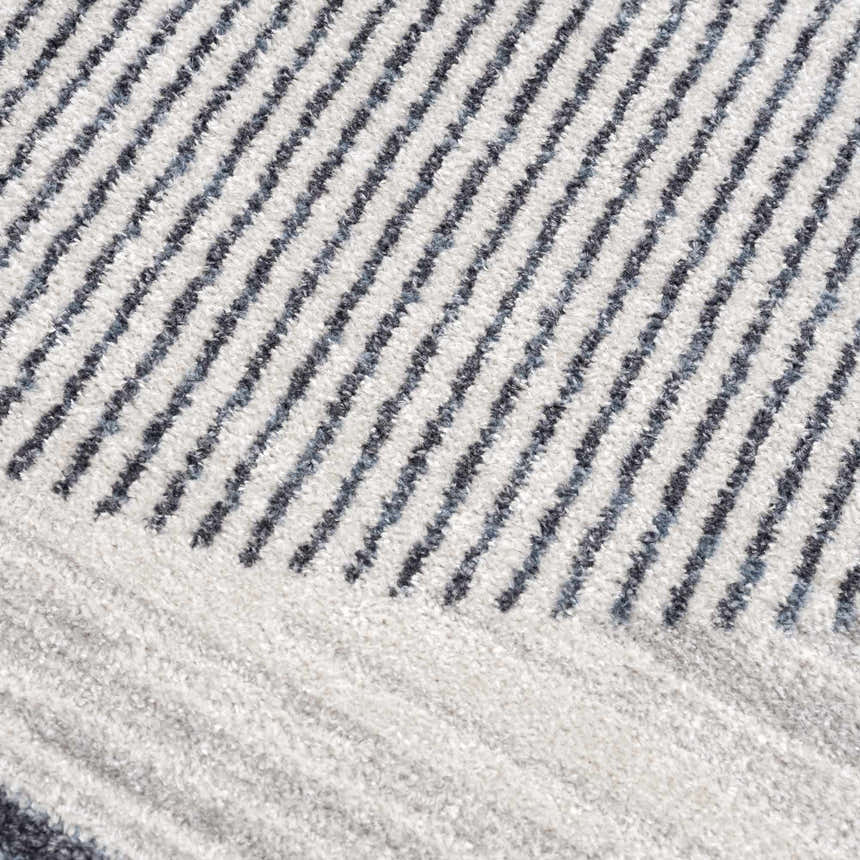 Close-up of the Thad Medium Gray Washable Area Rug, featuring a textured geometric stripe pattern in bone, gray, and dark gray. Texture