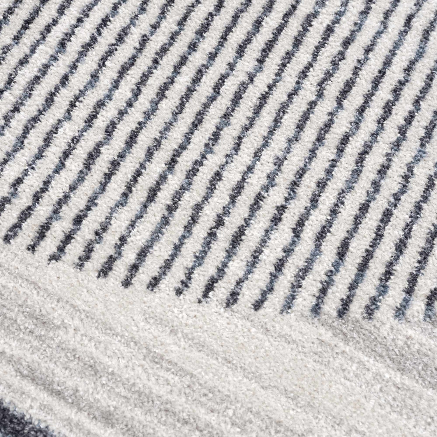 Close-up of the Thad Medium Gray Washable Area Rug, featuring a textured geometric stripe pattern in bone, gray, and dark gray. Texture