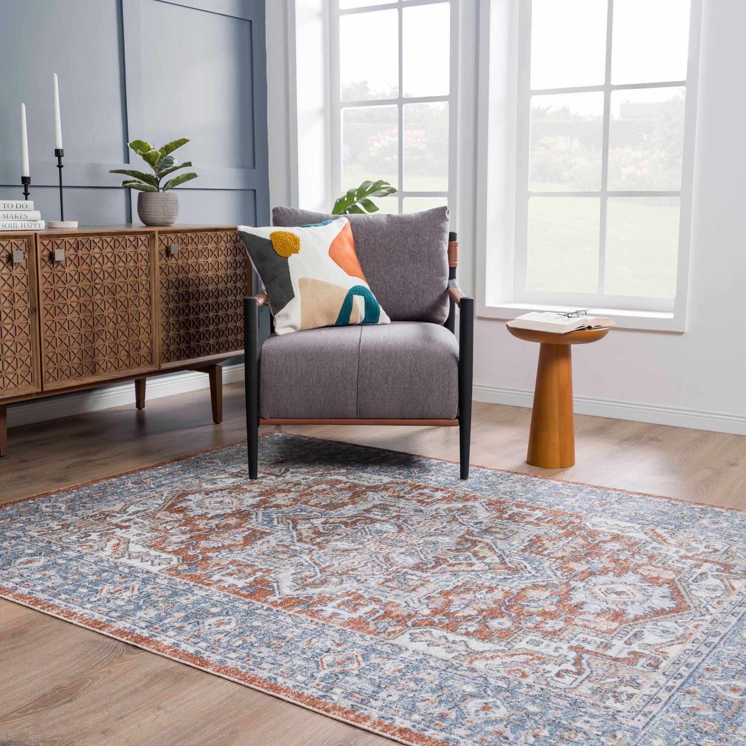 Living room scene with Ember Washable Area Rug in Beachhouse. Farmhouse style with gray chair, wood cabinet, and natural light. Roomscene-Rectangle