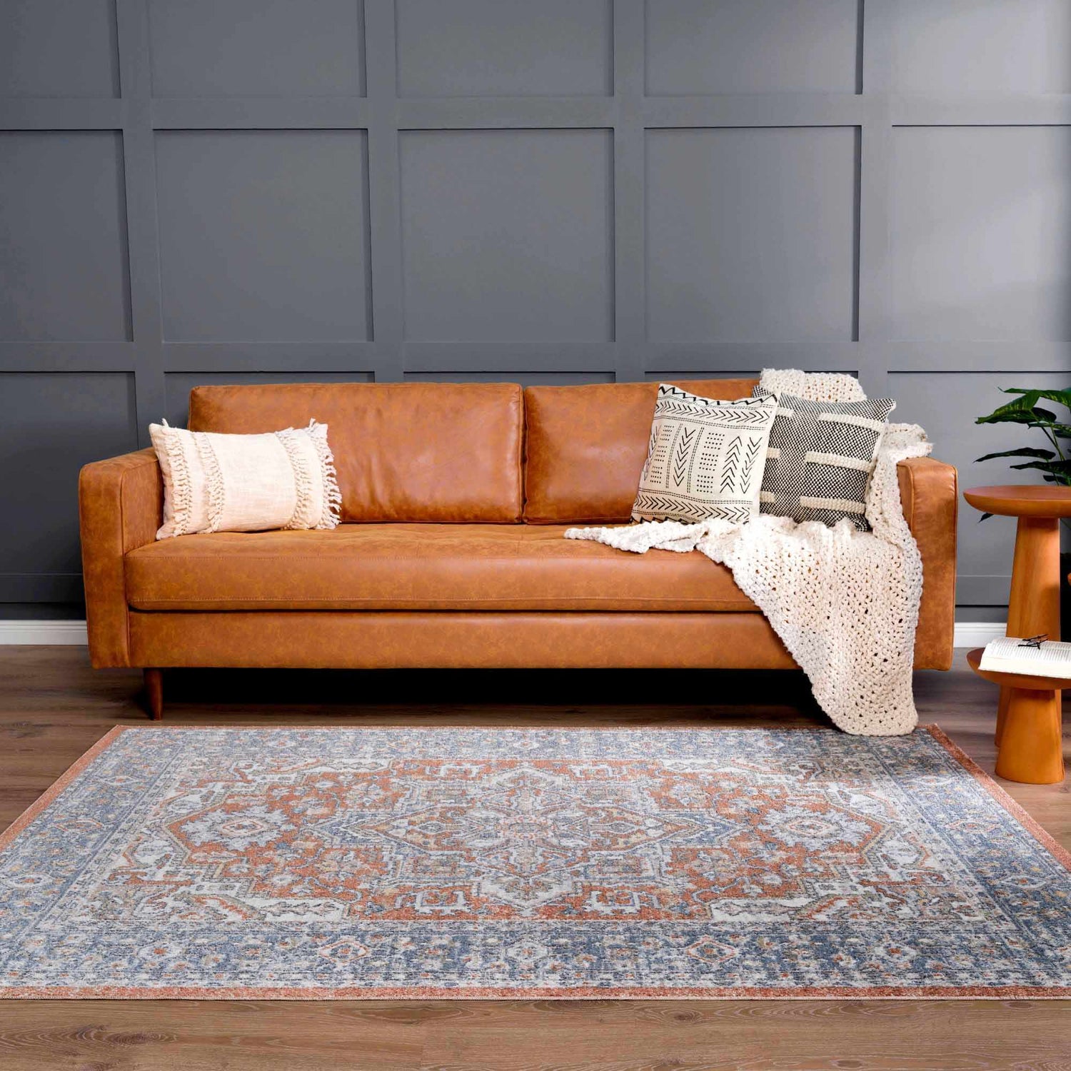 Living room scene with a brown leather sofa and the Ember Washable Area Rug in Beachhouse color. Roomscene-Rectangle