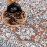 Close-up of Ember Washable Area Rug in faded driftwood, copper, and blue. Traditional pattern with farmhouse style. Styleshot