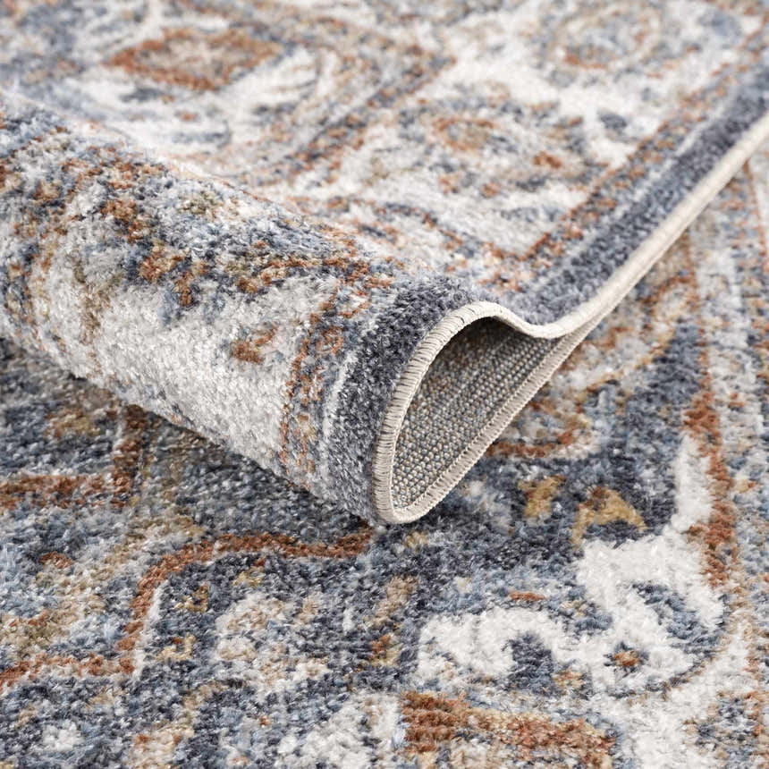Close-up of Aurum Blue & Beige Washable Area Rug, showing traditional pattern, texture, and colors. Fold