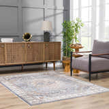 Living room with Aurum Blue & Beige Washable Area Rug, wood cabinet, gray chair, and natural light. Farmhouse style. Roomscene-Rectangle