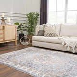 Living room scene with Aurum Blue & Beige Washable Area Rug, cream sofa, wood cabinet, and plants. Farmhouse style. Roomscene-Rectangle