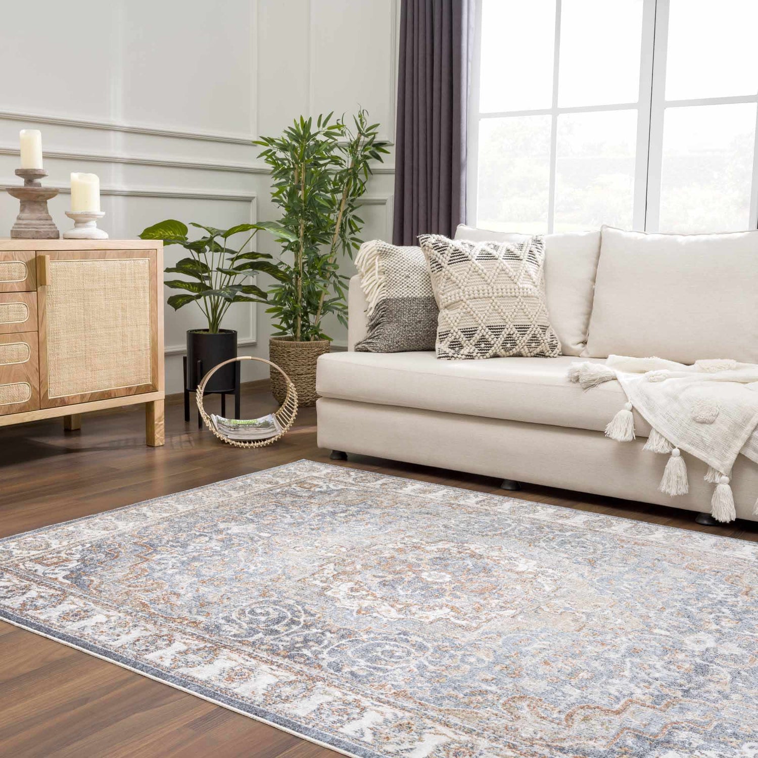 Living room scene with Aurum Blue & Beige Washable Area Rug, cream sofa, wood cabinet, and plants. Farmhouse style. Roomscene-Rectangle