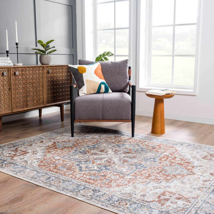 Living room scene with a Neta Red & Blue Flat Pile Washable Rug, gray chair, wood cabinet, and natural light. Roomscene-Rectangle