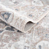 Close-up of the Dobry Boutique Washable Rug showing the blue, tan, and off-white vintage pattern and soft texture. Fold
