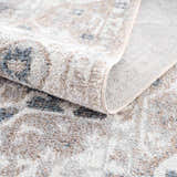 Close up of the Dobry Boutique Washable Rug showing the blue, tan, and off-white oriental pattern and soft, textured material. Fold