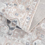 Close up of Dobry Boutique Washable Rug. Blue, off white, and tan vintage oriental pattern. Machine woven polyester rug. Fold