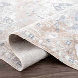 Close-up of the Dobry Boutique Washable Rug showing its blue, off-white, and tan vintage-style pattern and texture. Fold