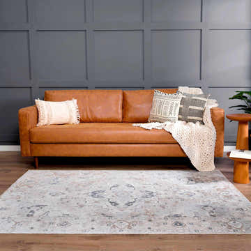 Living room with a tan leather sofa and Dobry Boutique Washable Rug in blue, off white, and tan. Roomscene-Rectangle
