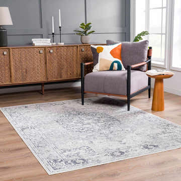 Living room scene with the Akram Antrasit flat pile rug, gray chair, wood cabinet, and light wood floors. Roomscene-Rectangle