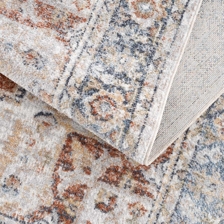 Close-up of the Akram Gray & Orange Washable Area Rug showing its traditional vintage pattern and polyester texture. Fold