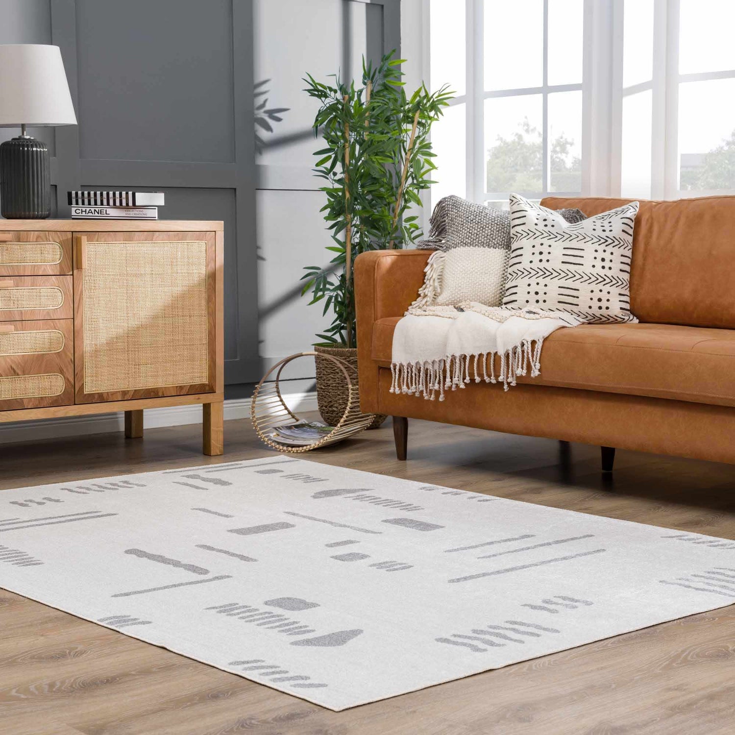 Living room scene with a brown leather sofa and the Eitan Modern Washable Off-White Rug. Roomscene-Rectangle