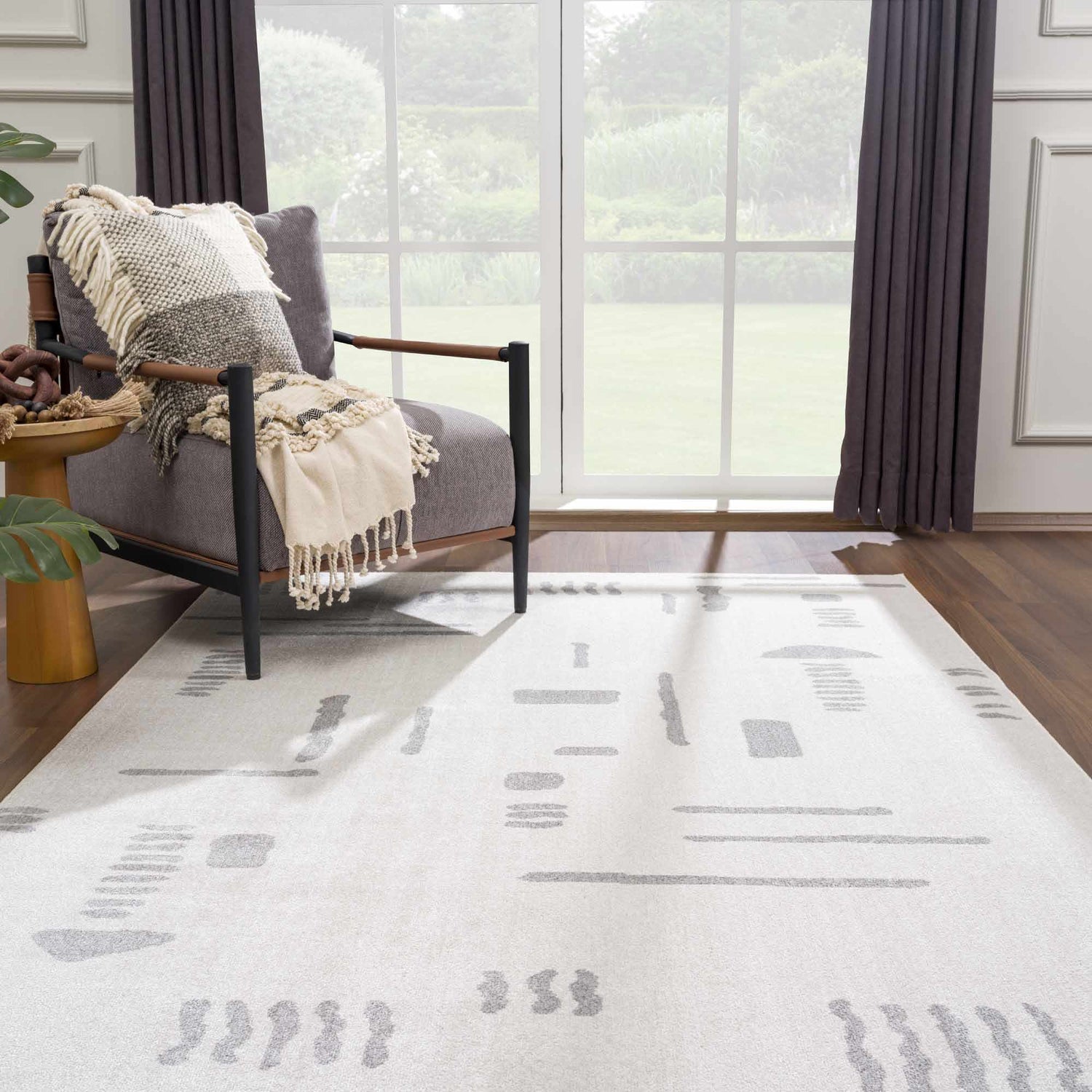 Living room scene with Eitan Modern Washable Off-White Rug, gray chair, and natural light. Abstract design. Roomscene-Rectangle