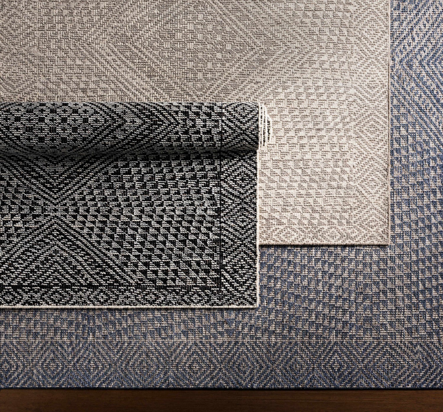 Close-up of Moyne Area Rug showing charcoal, white, and navy geometric patterns and textures. Styleshot