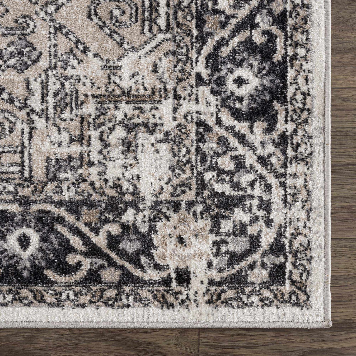 Close-up of the Cabacungan Washable Area Rug. Black, gray, light beige, and taupe vintage-style pattern. Swatch