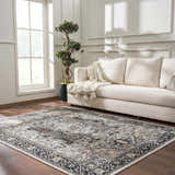 Living room with a neutral sofa and the Cabacungan Washable Area Rug in black, gray, and beige on a wood floor. Roomscene-Rectangle