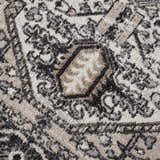 Close-up of the Cabacungan Washable Area Rug. Features a traditional pattern in black, gray, light beige, and taupe. Texture
