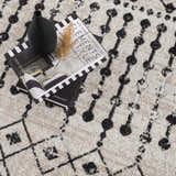 Close-up of the Joppatowne Washable Area Rug featuring a black geometric pattern on a cream and light beige background. Styleshot