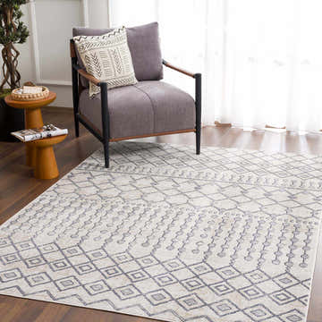 Living room scene with gray chair and geometric Midstream Washable Area Rug in gray, ink blue, and light beige. Roomscene-Rectangle