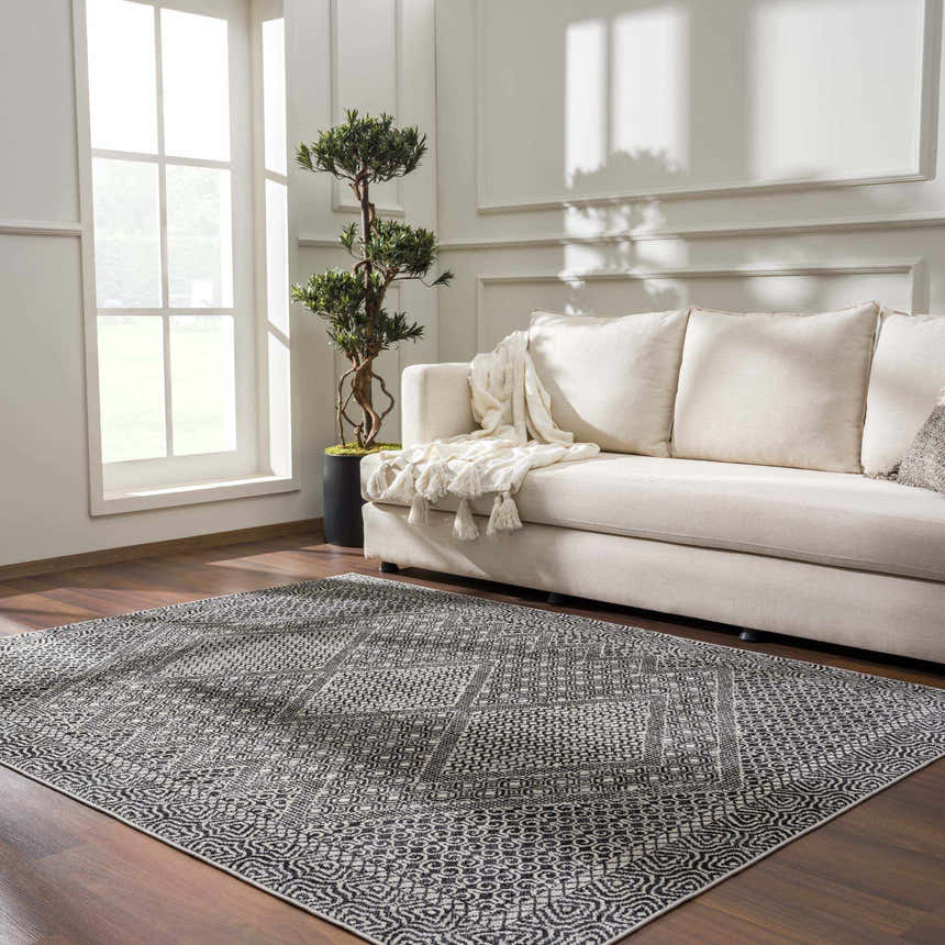 Living room scene with a Coledale Black & White Washable Rug, cream sofa, wood floors, and natural light from a large window. Roomscene-Rectangle