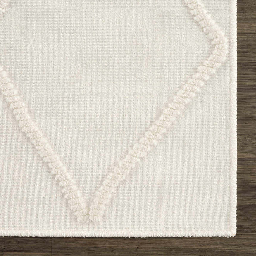 Close up of Amani White Washable Rug showing geometric pattern, woven texture, and plush, raised details. Swatch