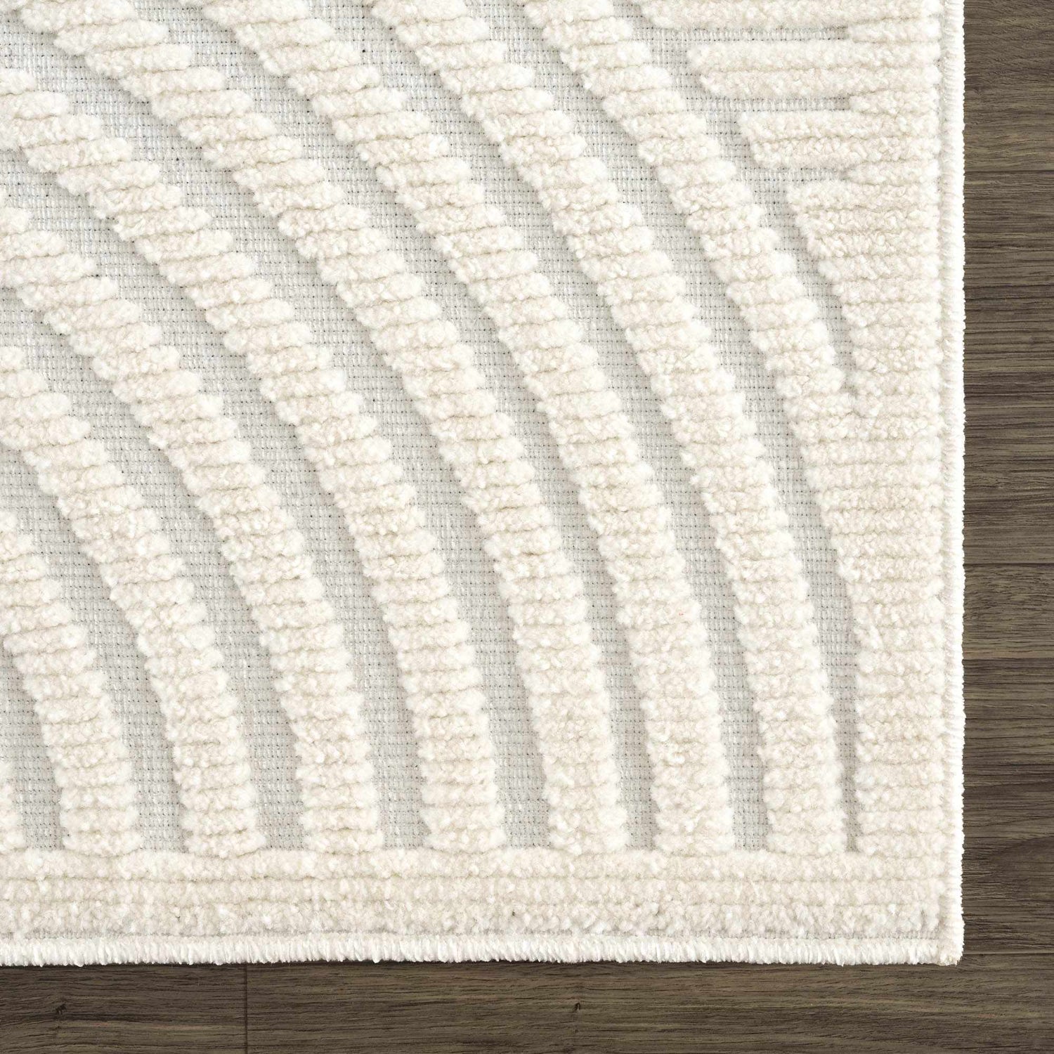 Close-up of the Deron White Washable 3D Rug. Features a geometric, curved pattern and plush texture in off-white tones. Swatch