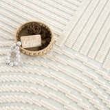 Close-up of the Deron White Washable 3D Rug featuring a geometric pattern and textured, off-white and gray color palette. Styleshot