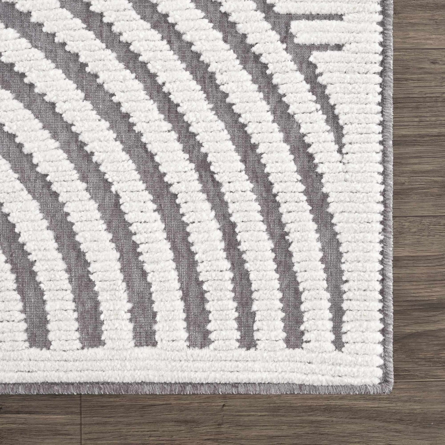 Close up of the Deron Gray Rainbow Washable Rug. Features a geometric pattern with gray and textured white stripes. Swatch