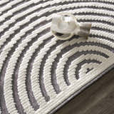 Close up of the Deron Gray Rainbow Washable Rug, featuring a geometric pattern in gray and white with a textured, machine-woven design. Styleshot