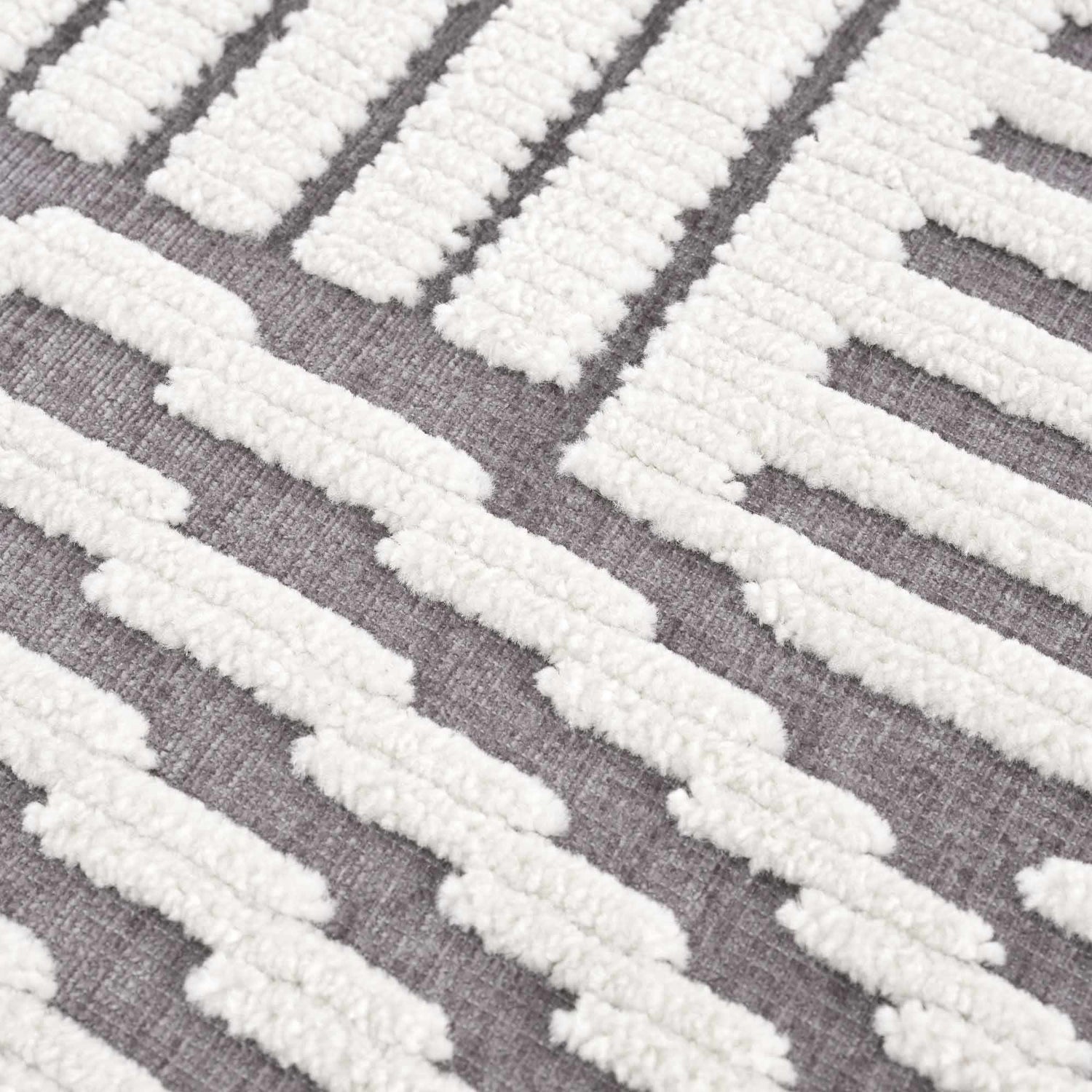 Close-up of the Deron Gray Rainbow Washable Rug, showing a geometric pattern in gray and textured white cotton. Texture