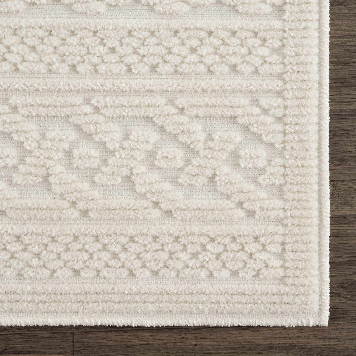 Close up of the Fadey White 3D Washable Rug showing geometric pattern and soft, textured pile on dark wood floor. Swatch