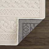 Close-up of the Fadey White 3D Washable Rug showing geometric texture, soft pile, and durable backing on wood floor. Fold