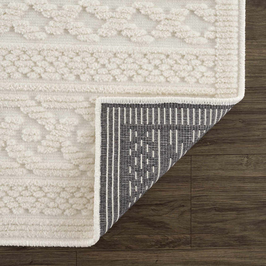 Close-up of the Fadey White 3D Washable Rug showing geometric texture, soft pile, and durable backing on wood floor. Fold