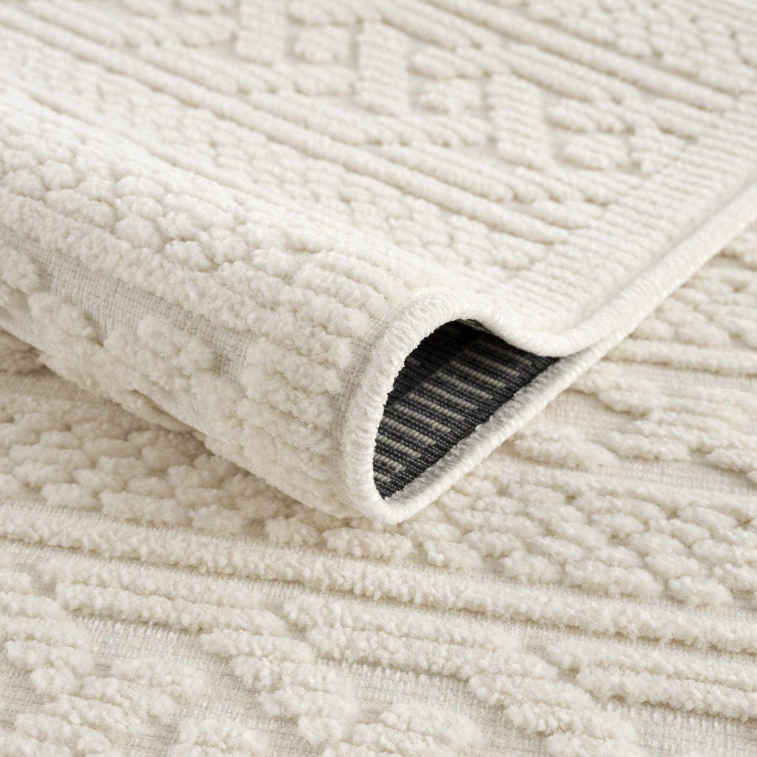 Close-up of the Fadey White 3D Washable Rug, showing the geometric pattern and plush, textured pile. Fold